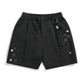 Man wearing black semi-elastic loose-fit shorts with a colour button fastening and zipper fly
