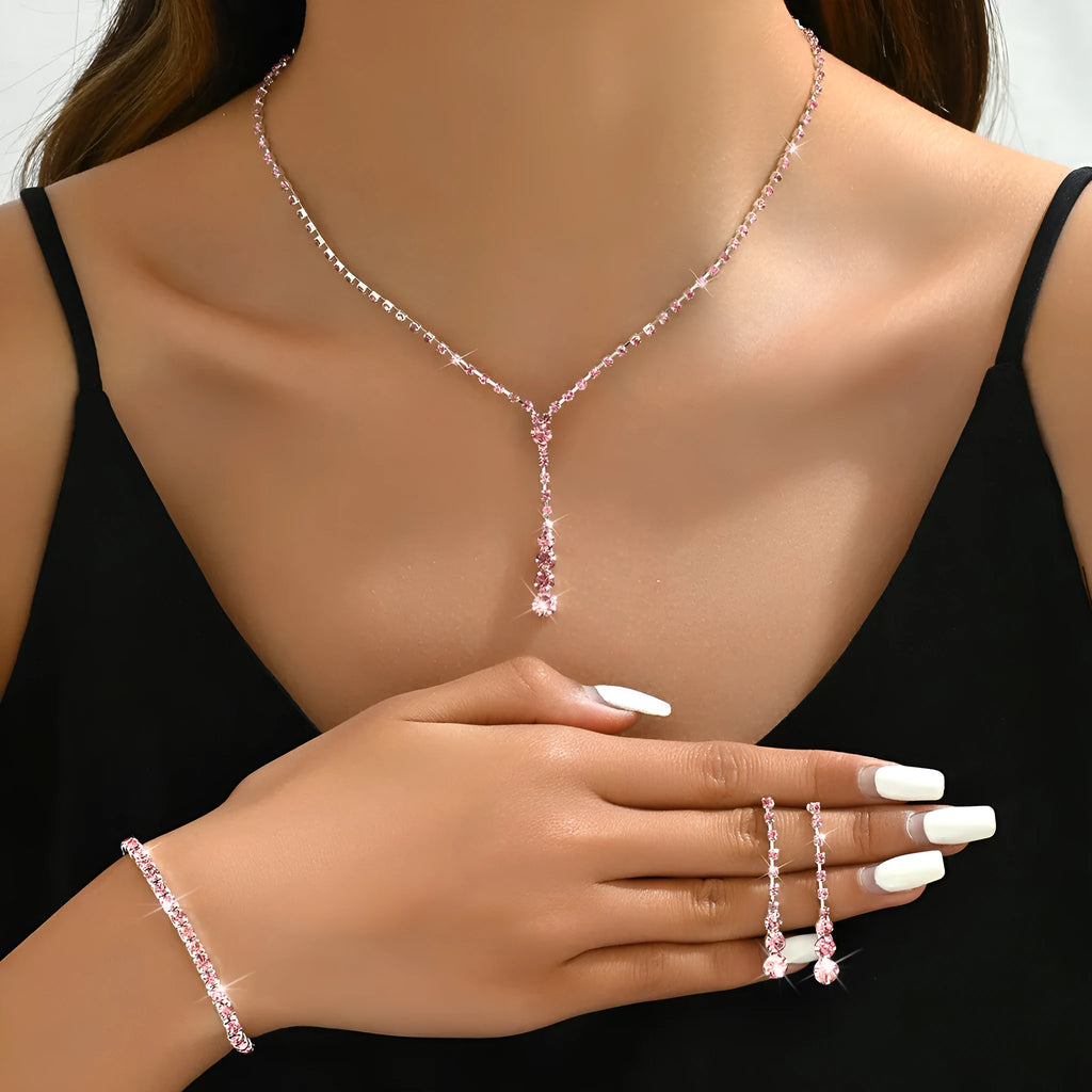 Women's three-piece bridal jewellery set showing earrings, necklace and bracelet with rhinestone heart-shaped pendant