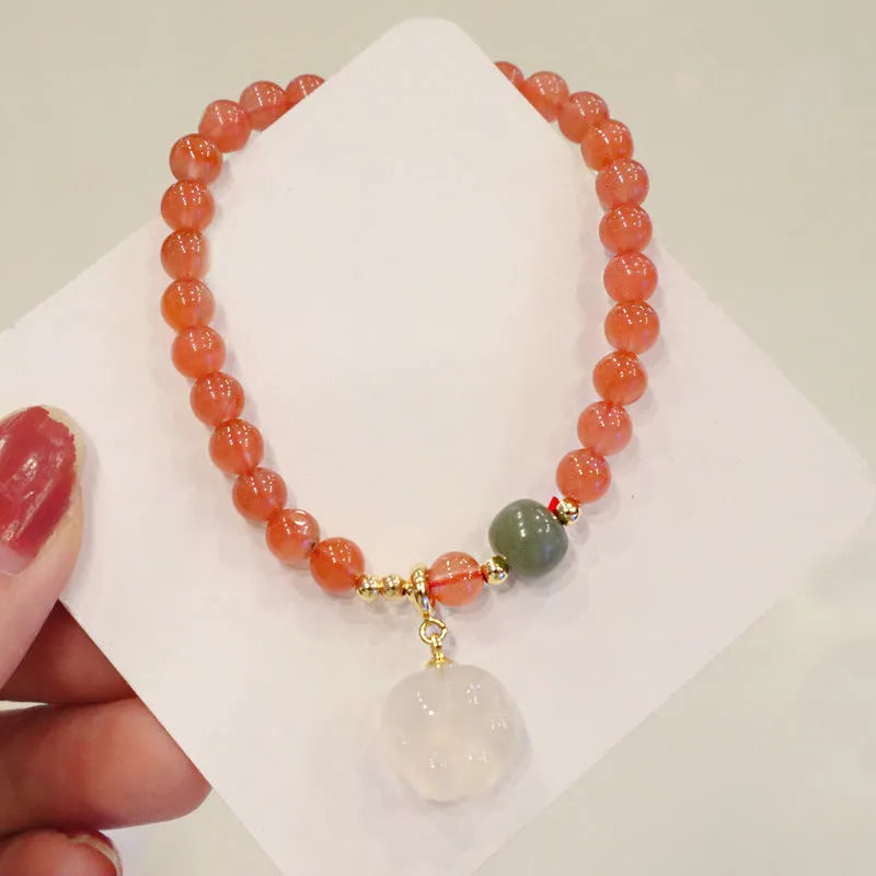 Polished agate bracelet with cat's paw charm and jade beads on adjustable cord.