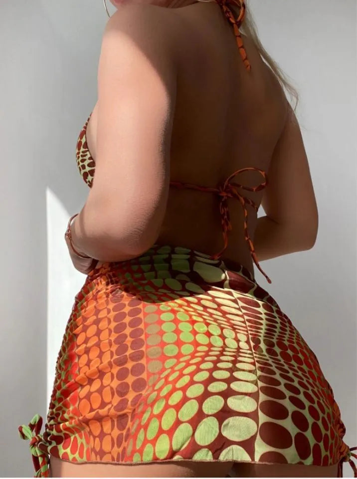 Printed split bikini set with chest pad, shorts, skirt, and headband in polyester on woman