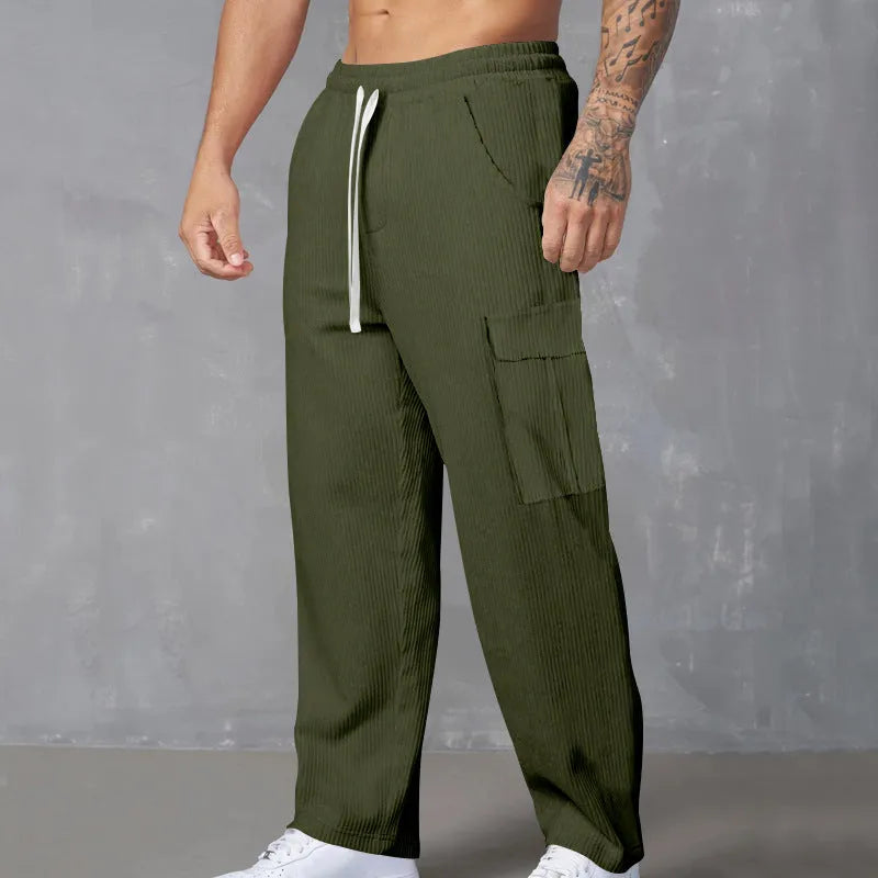 Men's navy blue corduroy cargo trousers with a drawstring waist and wide straight legs laid flat.