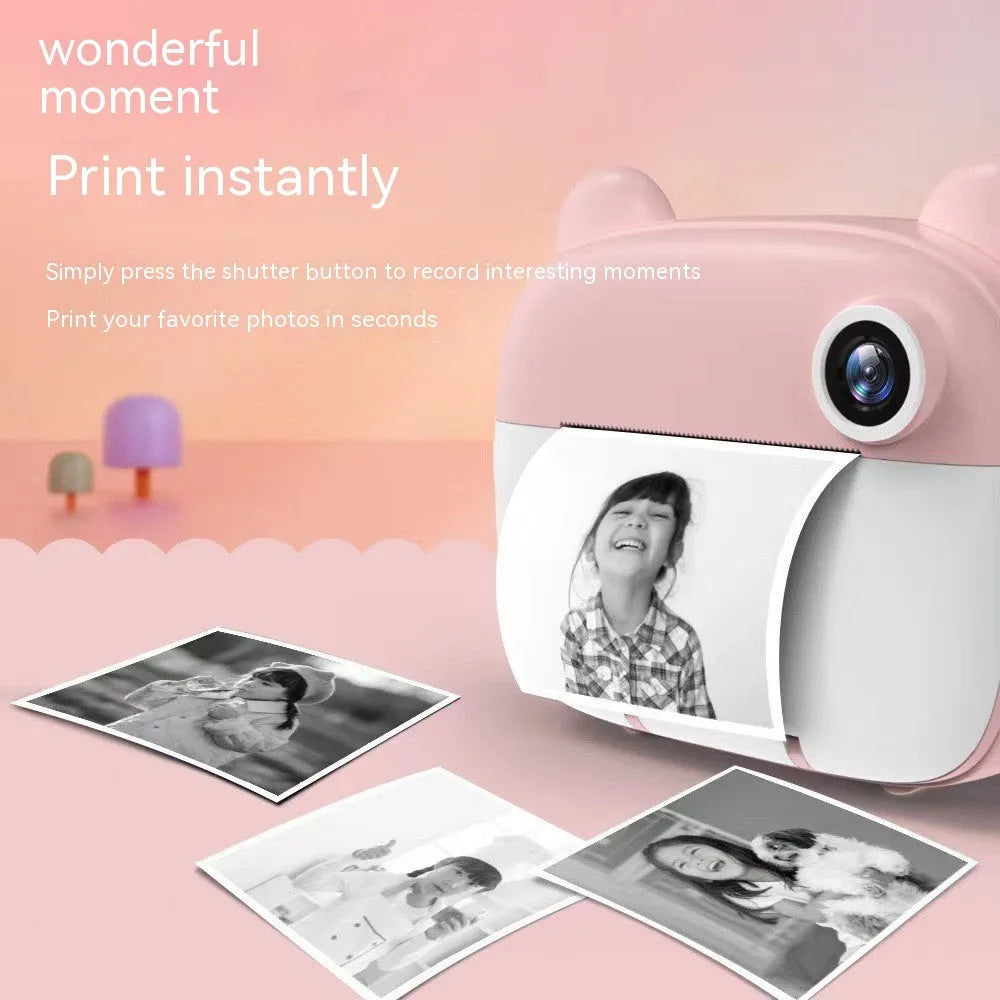 Pink children's printing camera with HD dual lenses, lanyard, and crayons on white background