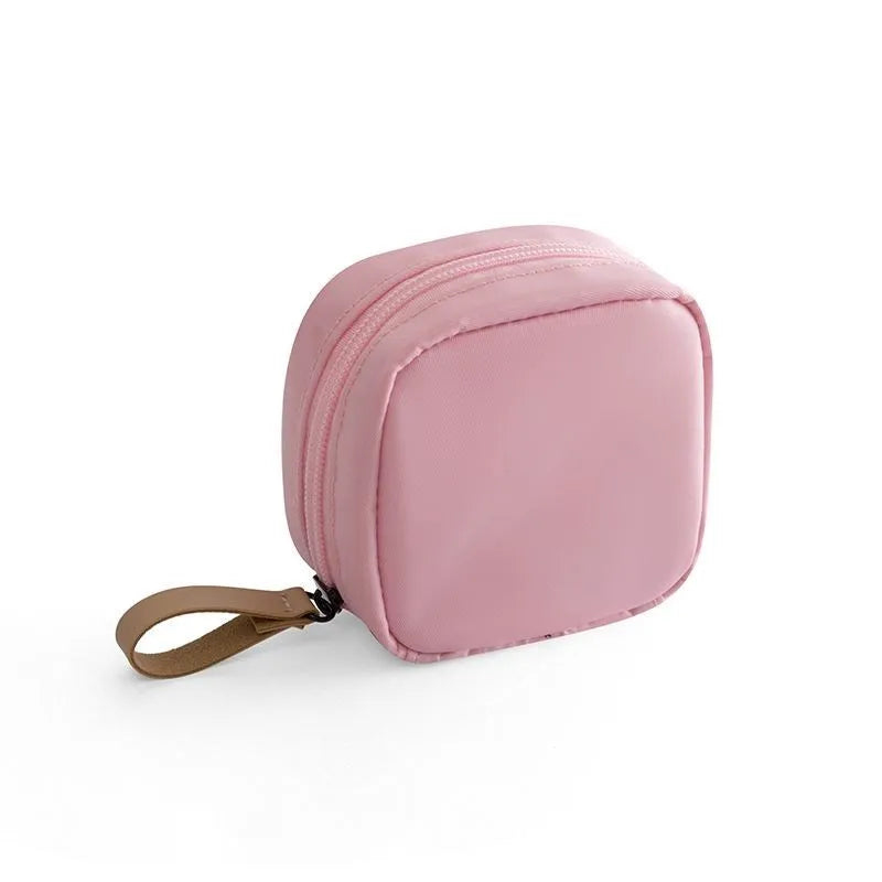 Blue cloth cube-shaped makeup storage bag with plain pattern, open to show interior space.