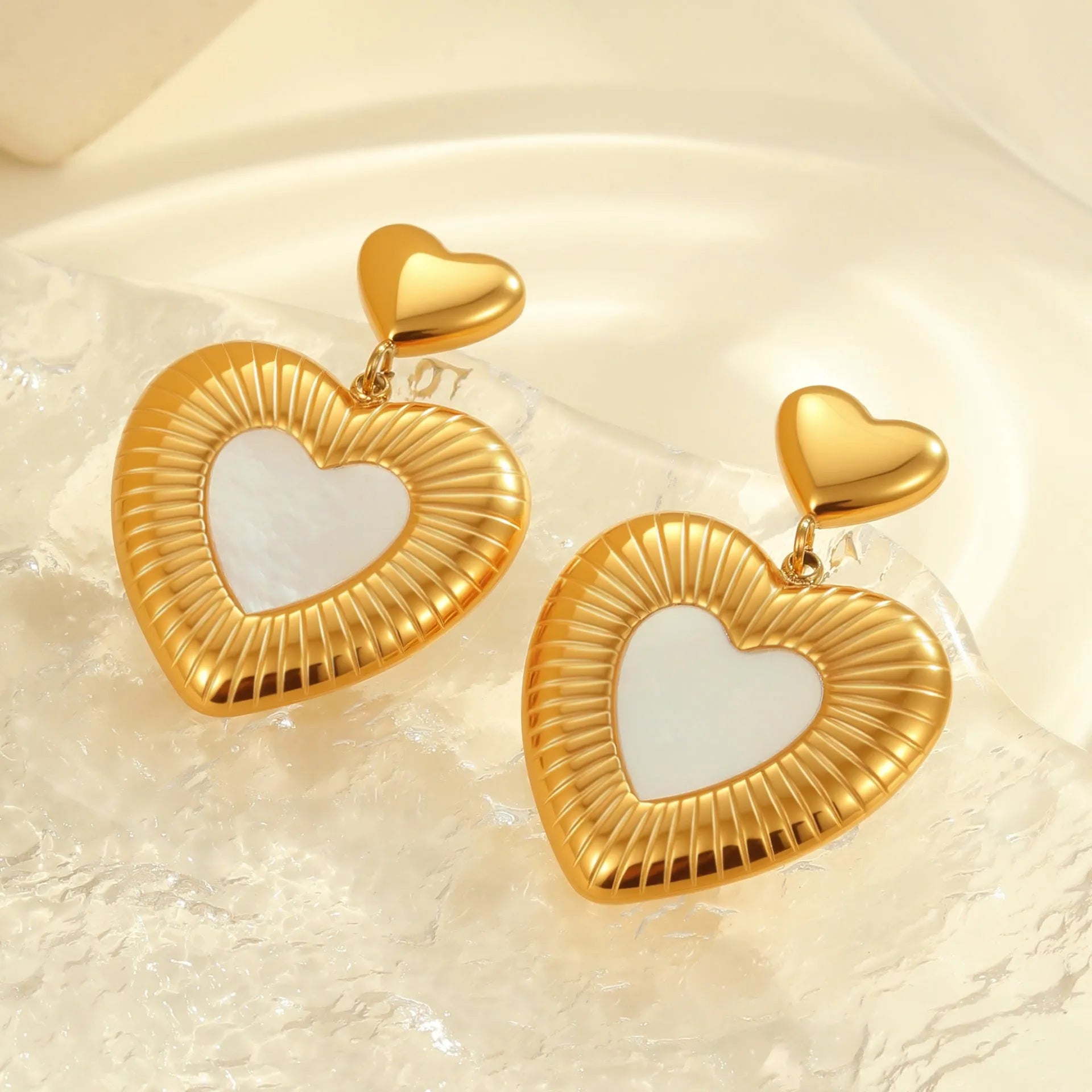 Gold electroplated heart-shaped stainless steel earrings with white fritillary detail