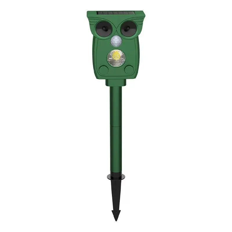 Dark green solar-powered animal repeller with infrared sensor on a garden lawn