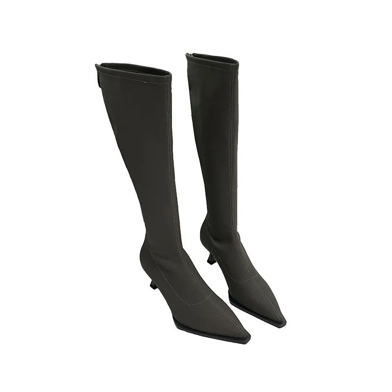 Women's black pointed toe below-knee boots with a stiletto heel and a back zipper on a plain background.
