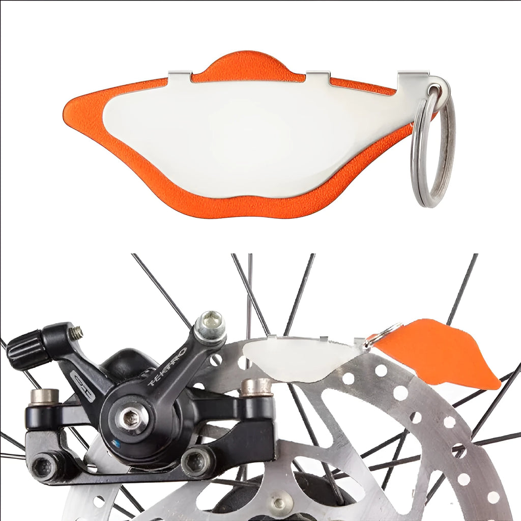 Mountain bike disc brake pads in black and orange with adjustment flap