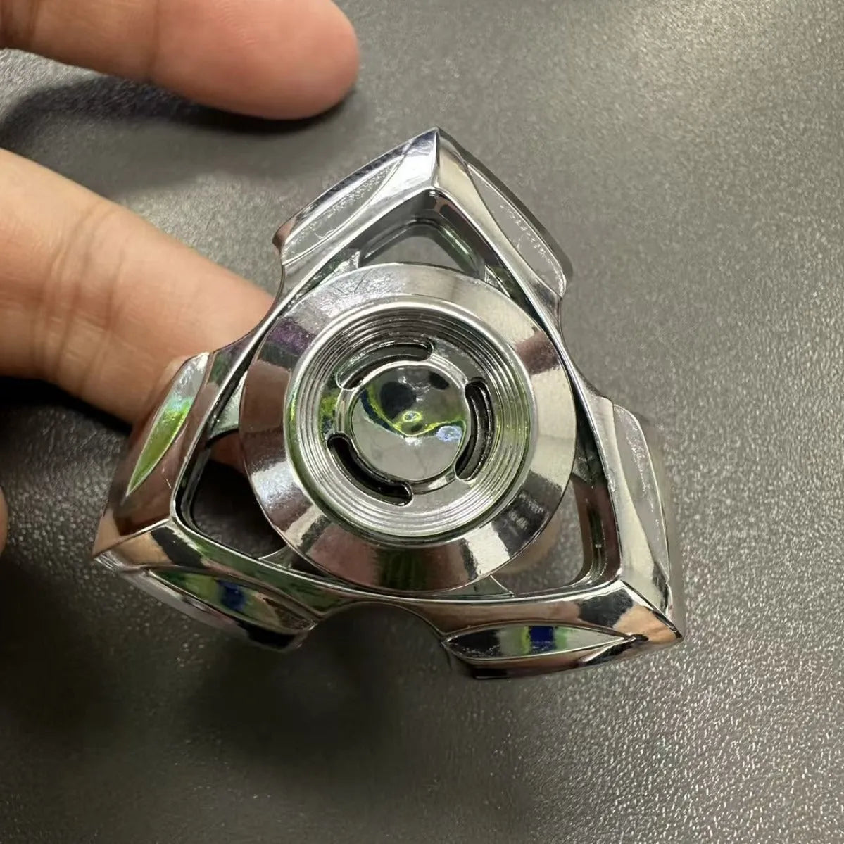 Close-up of a silver and colourful alloy metal fingertip gyro decompression spinner toy.