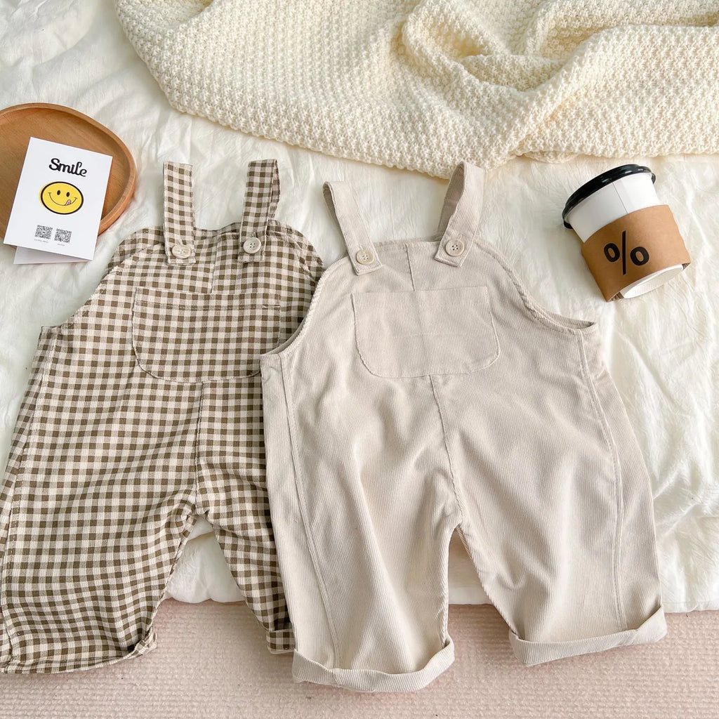 Infant cotton corduroy overalls in creamy white with large front pockets and double-breasted closure