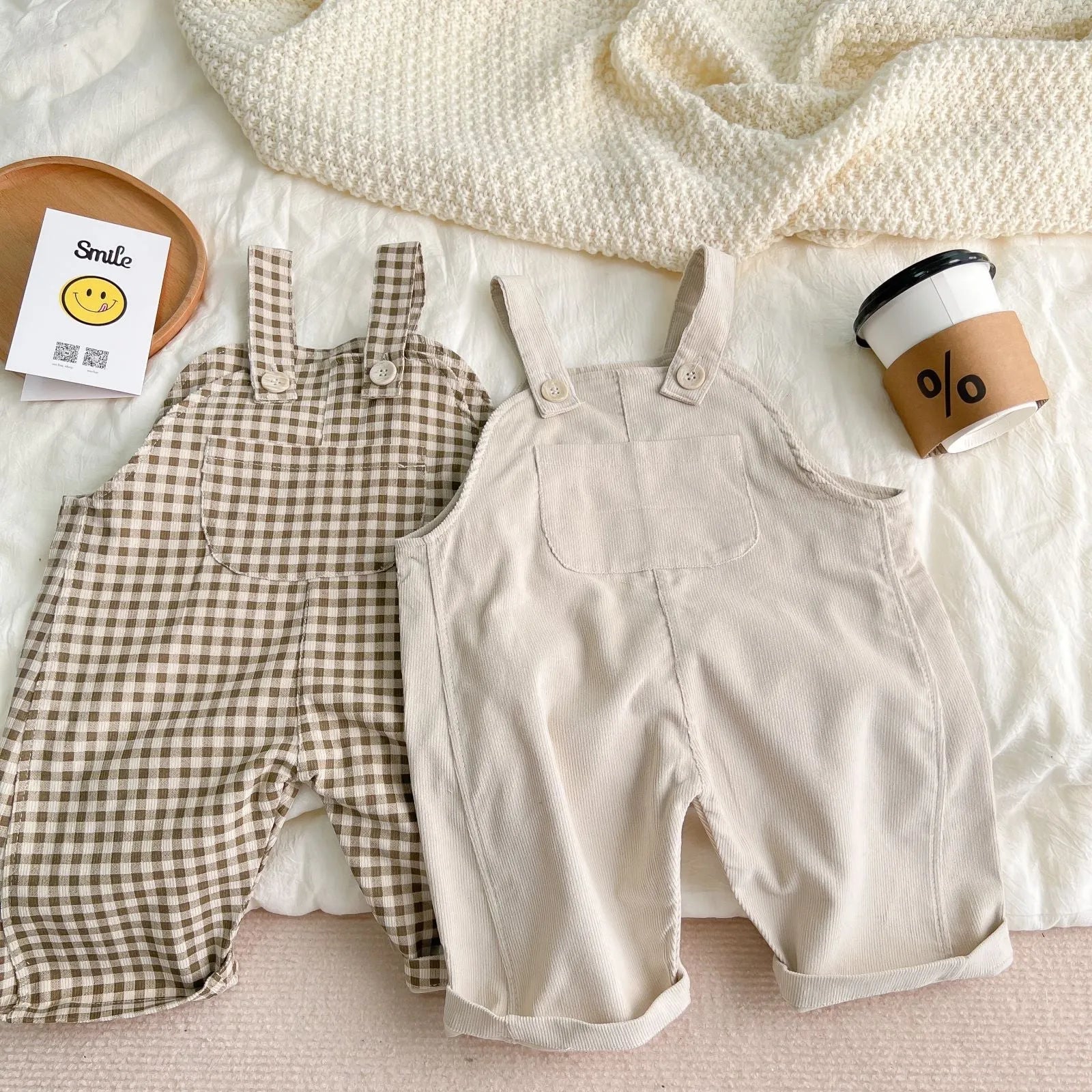 Infant cotton corduroy overalls in creamy white with large front pockets and double-breasted closure
