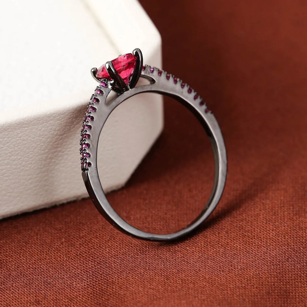 Hexagonal geometric zircon ring in copper with an electroplated gun black purple finish on a finger.