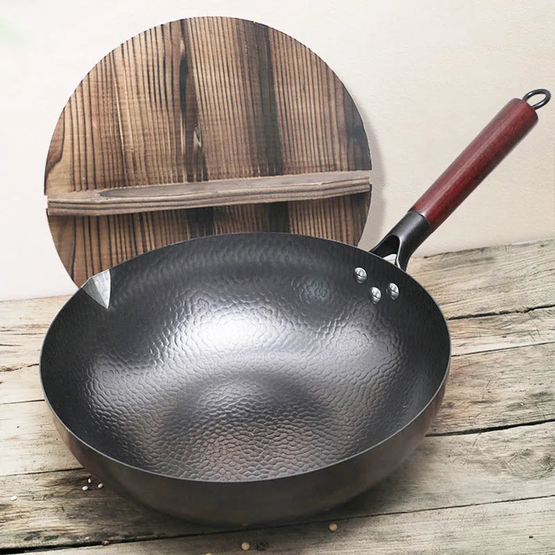 Traditional black iron wok with a long wooden handle, shown with a glass lid.