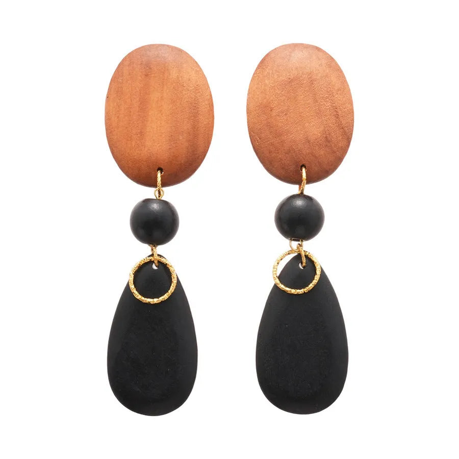 Pair of brown-black retro wooden ellipse earrings for women on a plain background.