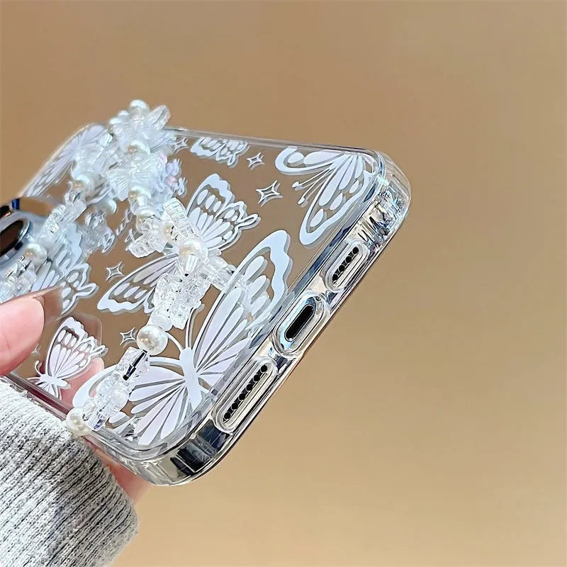 Transparent iPhone case with a built-in round mirror and a painted pink bow decoration on the back.