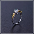 Black gold finished copper ring with a detailed crown motif and crystal settings on a finger.