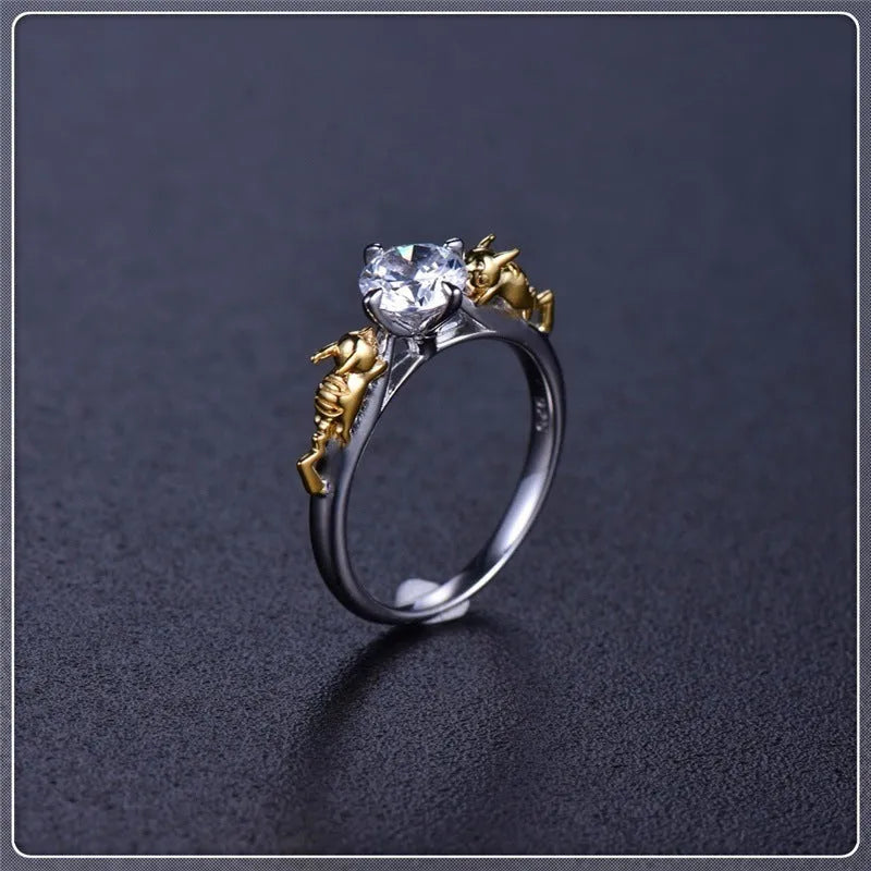 Black gold finished copper ring with a detailed crown motif and crystal settings on a finger.