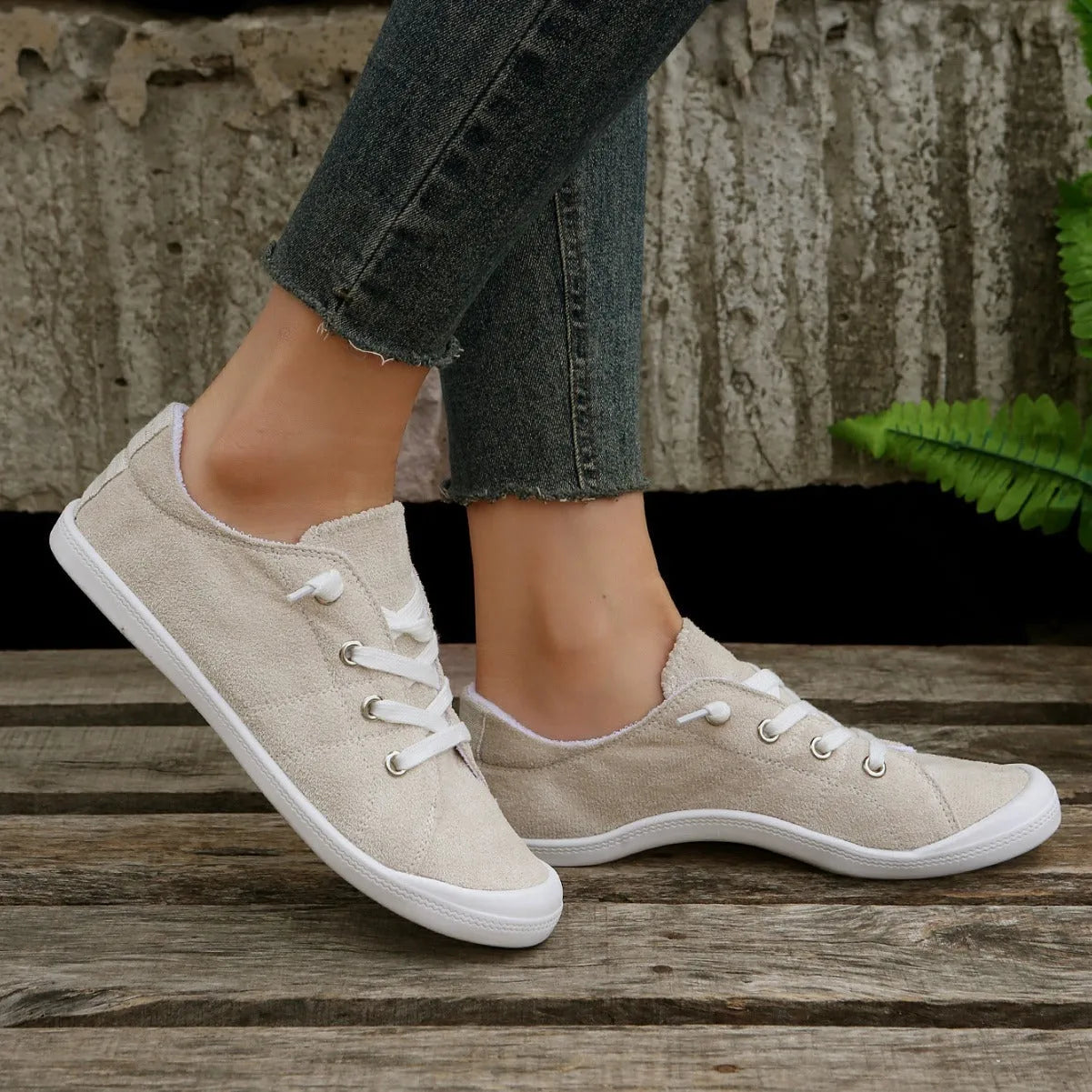 Women's creamy white casual low-top sneakers with fabric upper and rubber sole on a neutral background.