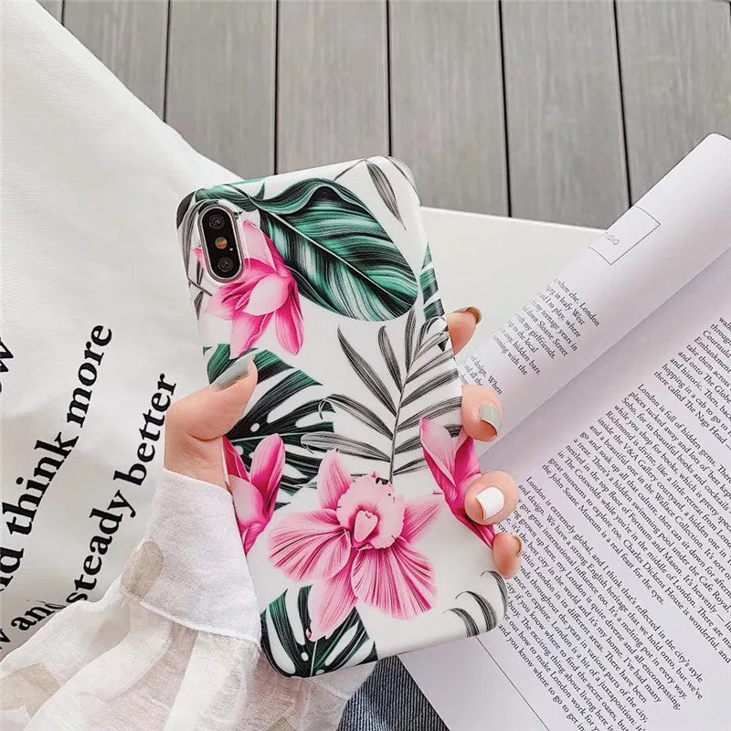 Pink floral pattern TPU back cover case for iPhone models on a table.