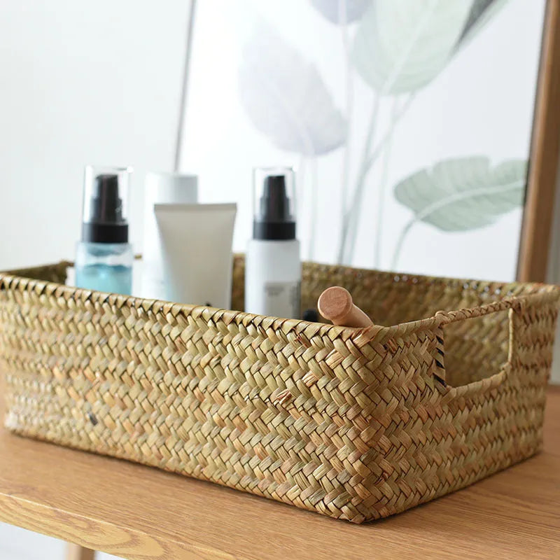 Handwoven grass rectangular storage baskets in various sizes on a wooden shelf