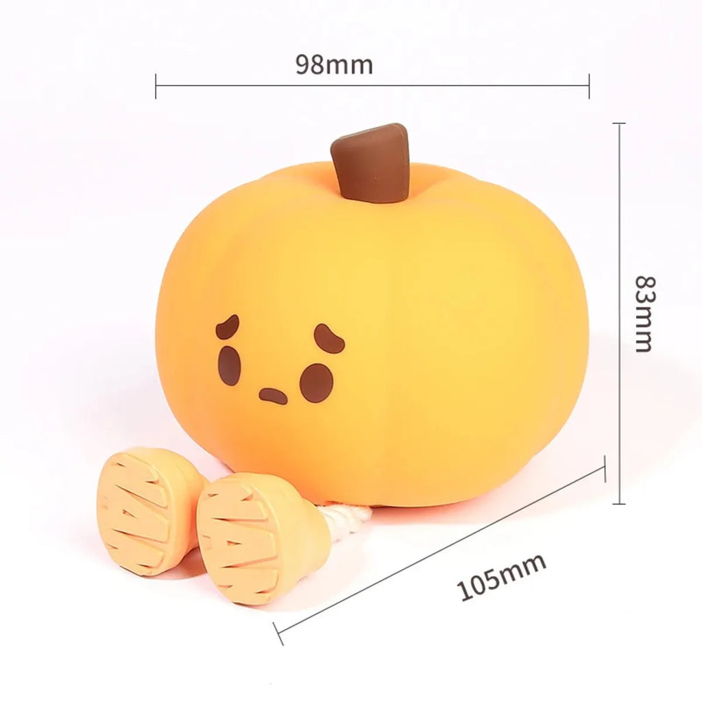 Pumpkin-shaped silicone night light with rechargeable battery on a bedside table