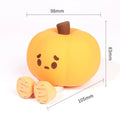 Pumpkin-shaped silicone night light with rechargeable battery on a bedside table