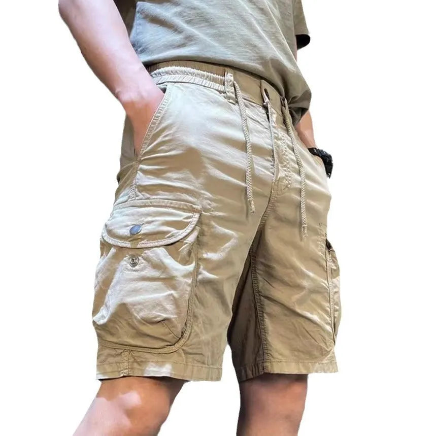 Man wearing loose straight-leg khaki overalls with multiple pockets, showcasing the Korean-style relaxed fit.