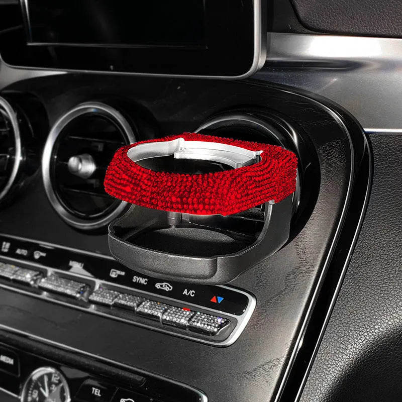 Rhinestone-encrusted white car cup holder bracket mounted on a vehicle air vent.