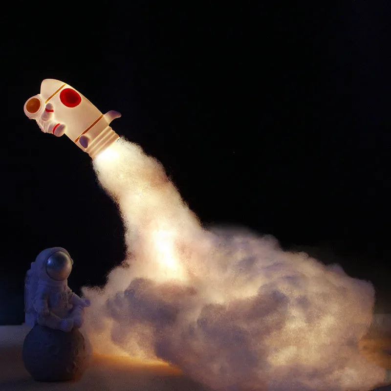 DIY Astronaut Rocket night light kit parts displayed with warm LED glow, showing rocket model, chassis, and string lights.