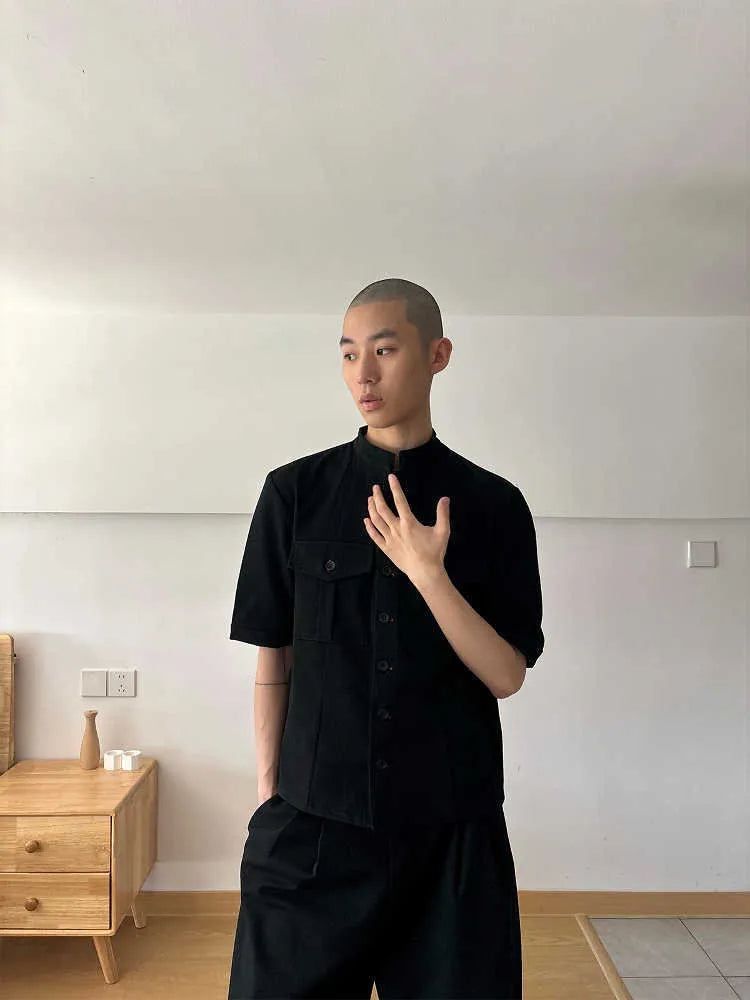 Handmade black half-sleeve hunting shirt with a shirt collar and single-breasted placket on a hanger.