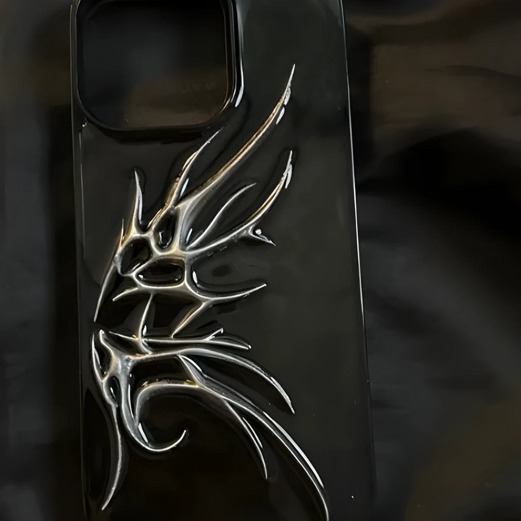 Black iPhone case with three-dimensional blurred wings design showing raised edges and precise port cutouts