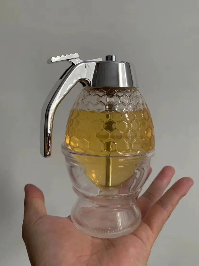 Transparent squeezable honey jar dispenser with 200ml capacity and bee design, sitting on a kitchen counter