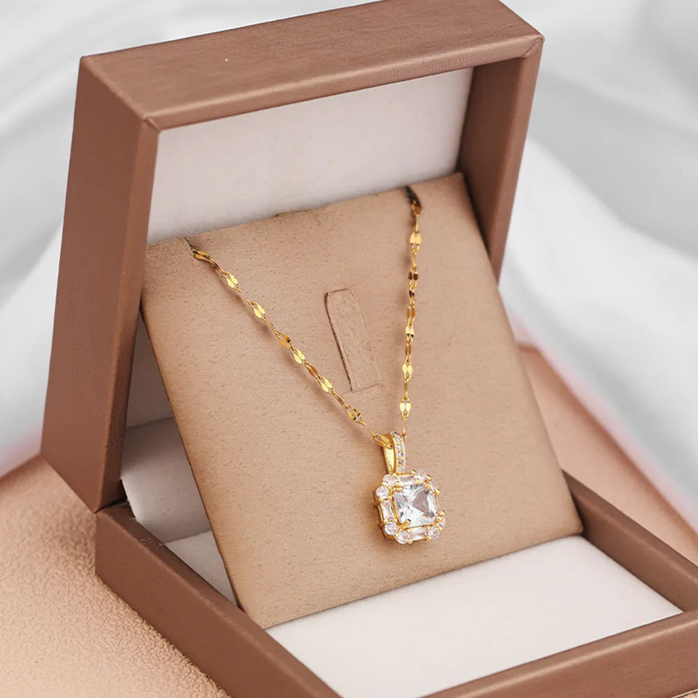 Gold geometric quadrilateral pendant necklace with gem inlay on a water wave chain.