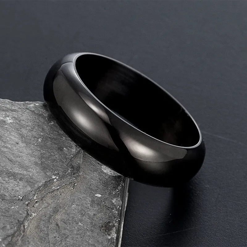 A glossy electroplated titanium steel ring in a gold colour, shown on a finger.