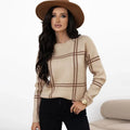 Women's apricot, black, beige, red and green plaid colour-block crew neck acrylic sweater on a hanger