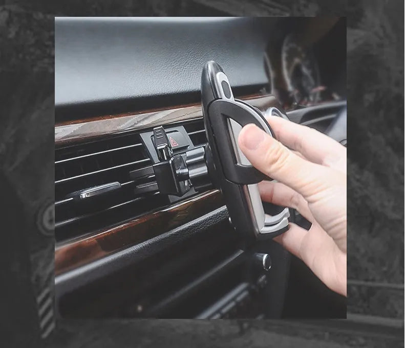 Black plastic car phone holder mounted on air conditioning outlet holding smartphone