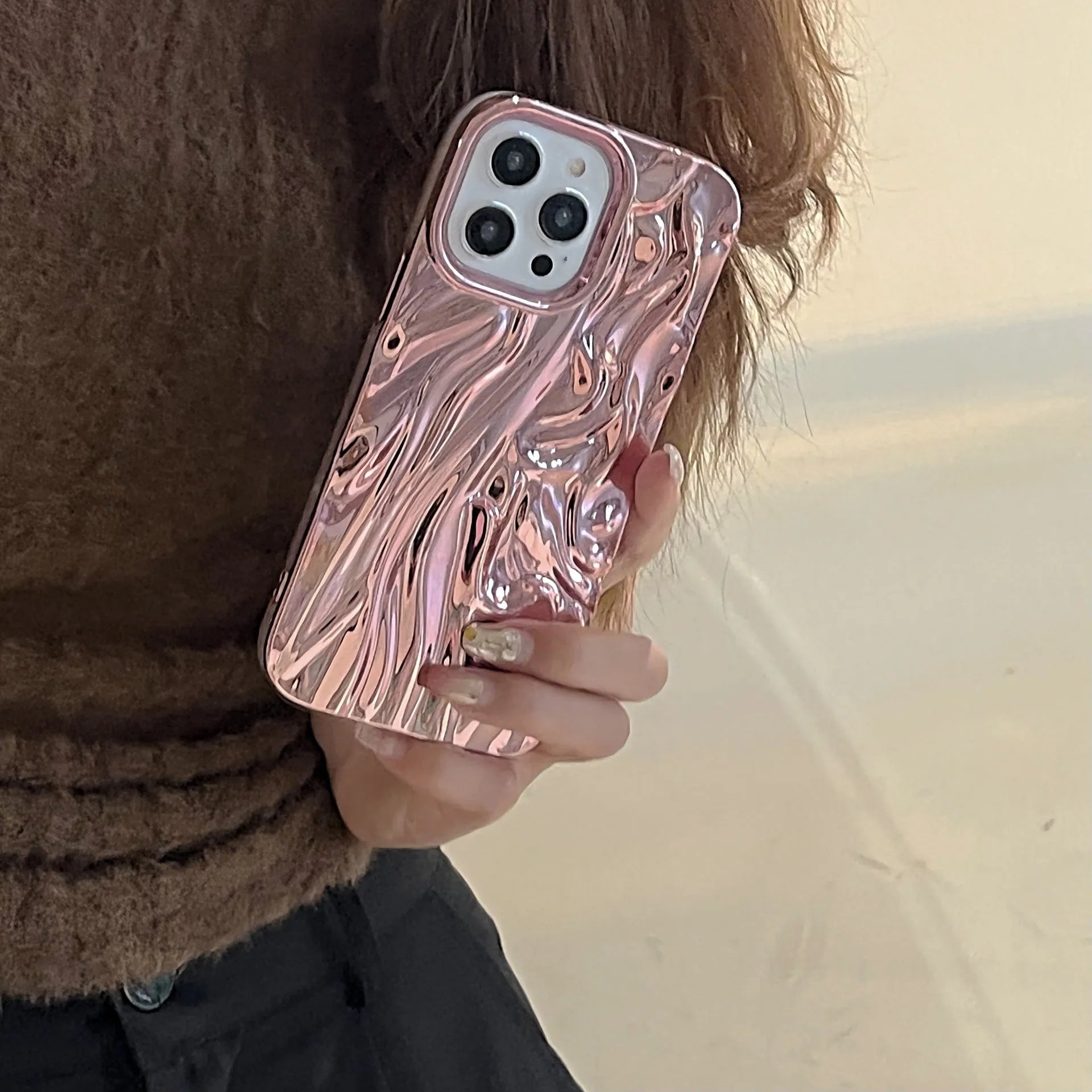 Soft TPU iPhone case with a textured three-dimensional pleated pattern in an electroplated gold finish.