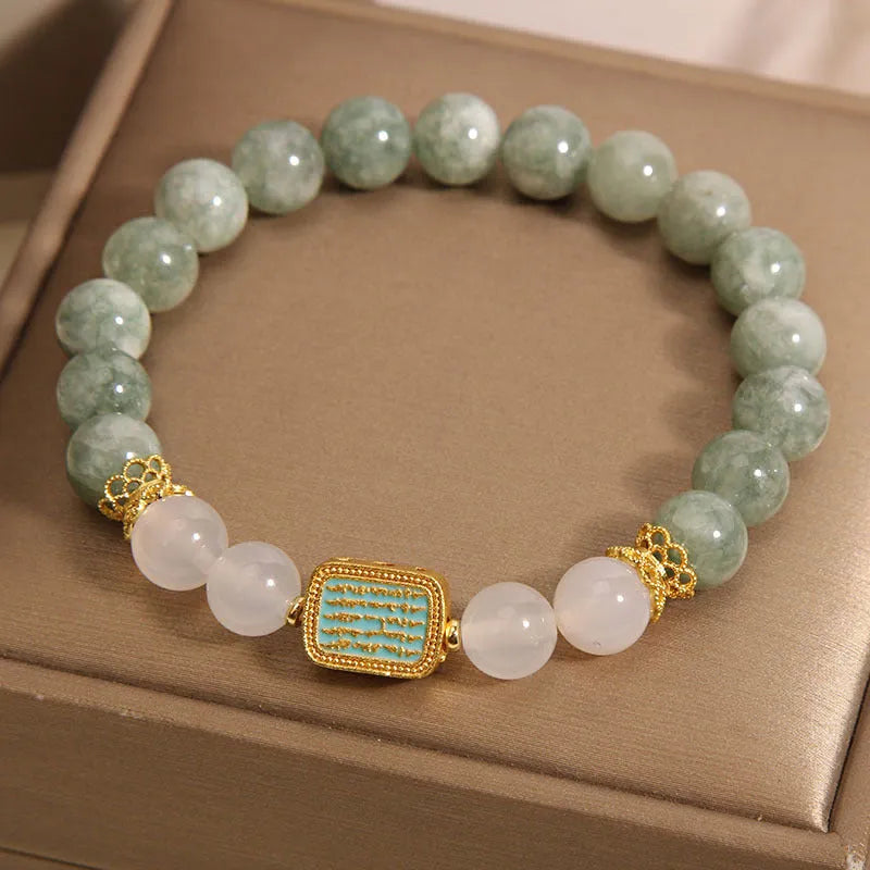 Women's oil green emerald crystal bracelet with five natural gemstones on a wrist.