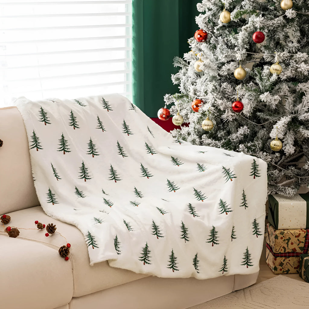 White polyester Christmas plush sofa blanket with embroidered Christmas tree design on a sofa