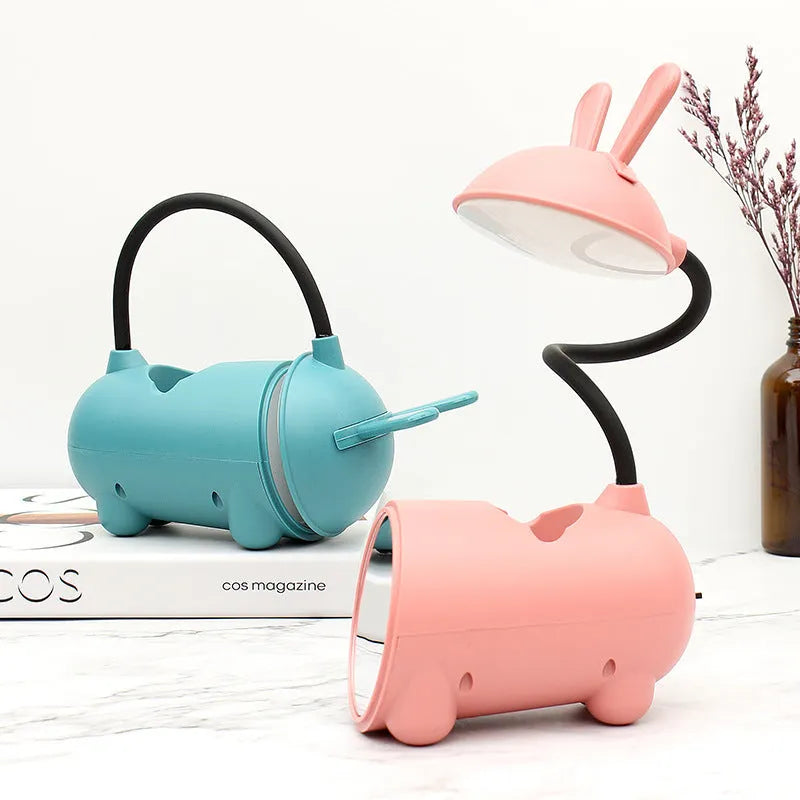 Cartoon-style USB table lamp with integrated pen container in green colour on wooden desk