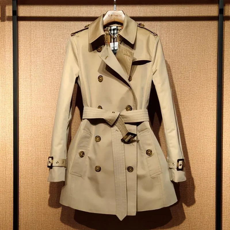 Khaki coloured women's double-breasted trench coat with flight sleeves on a hanger.