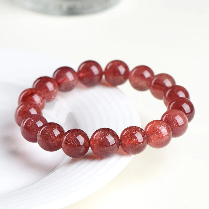 Geometric bead strawberry quartz bracelet in Starlight colour on a wrist, showing size options.