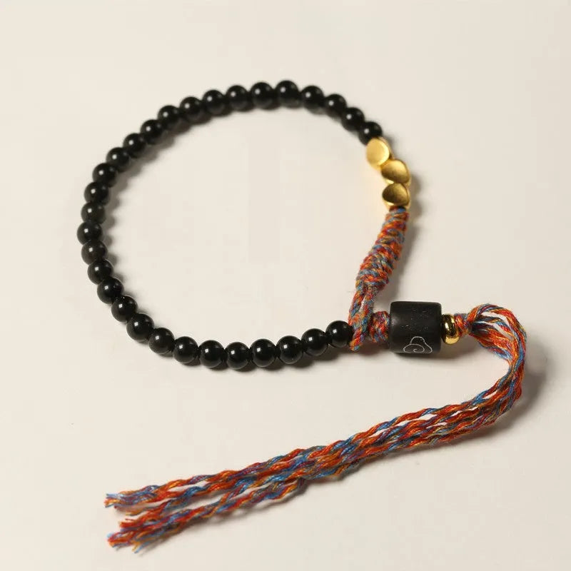 Hand-woven obsidian carrying strap bracelet showing textured surface and adjustable length