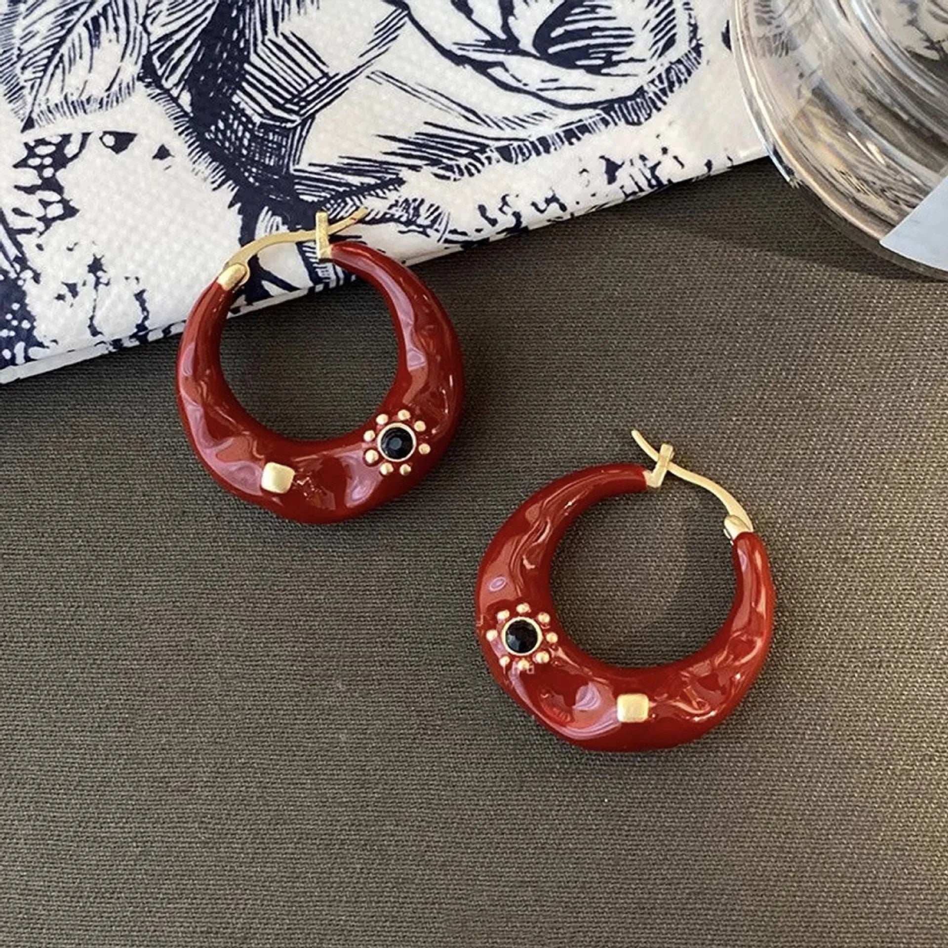 A pair of retro-style alloy ear studs with inlaid rhinestones, shown in black and red colour options.