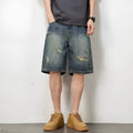 Man wearing blue retro loose hole distressed denim shorts with a straight leg cut