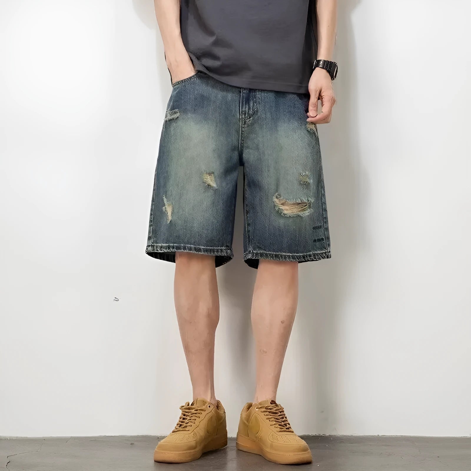 Man wearing blue retro loose hole distressed denim shorts with a straight leg cut
