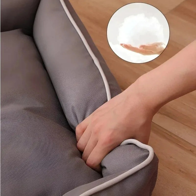 Grey waterproof dog sofa bed with cushioned sides on a wooden floor.