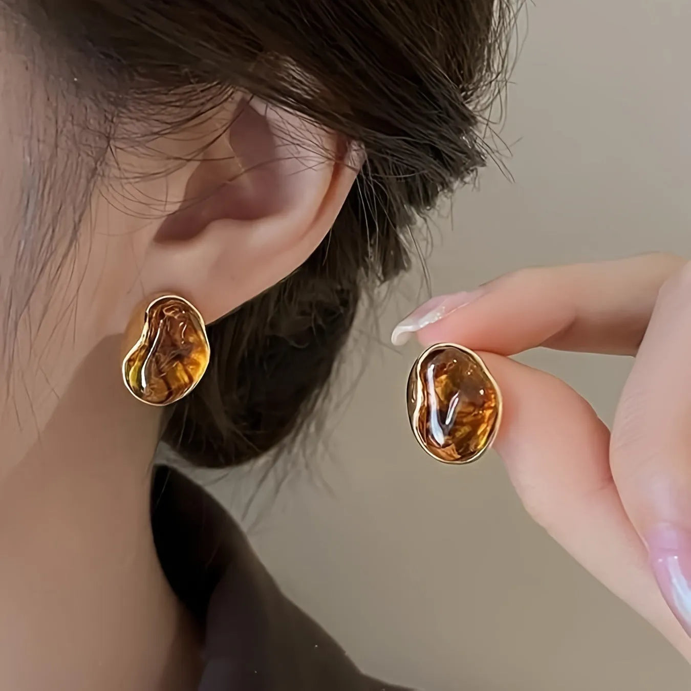 Handmade geometric alloy earring set showing three styles: round pieces, amber studs, and tigereye drops with tassels.