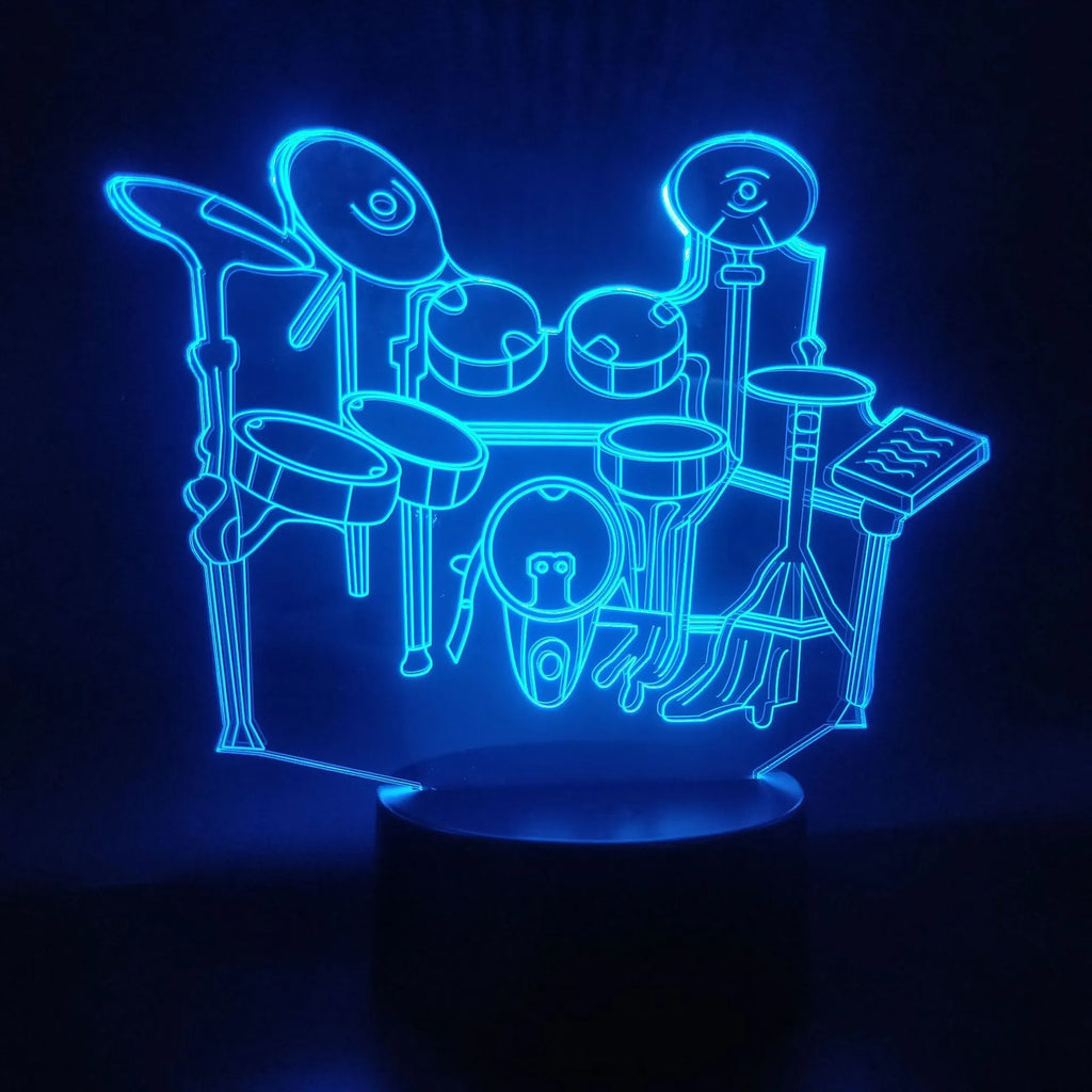 Drum kit shaped 3D LED night light with colourful illumination on a dark surface.