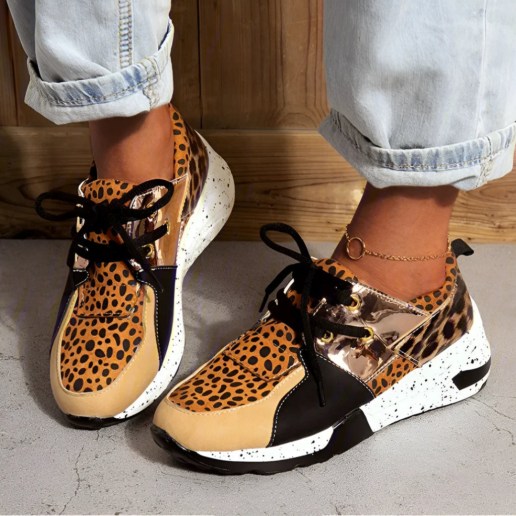 Women's casual wedge heel sneakers in suede, showing round toe and low-cut profile on a wooden floor.