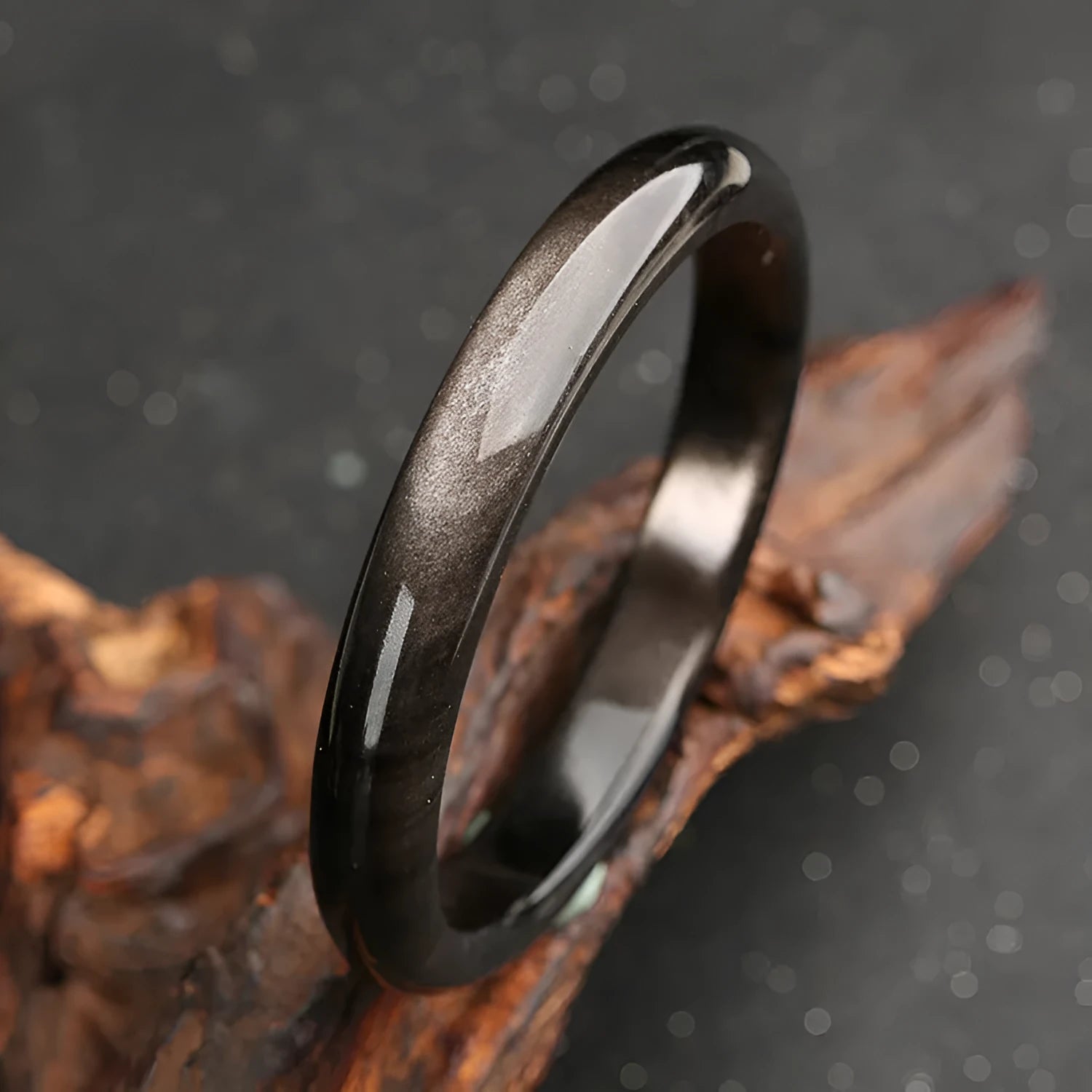 Silver cat's eye crystal stone set in a geometric alloy ethnic bracelet on a wrist.